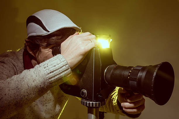istock Man with old film movie camera 512967402