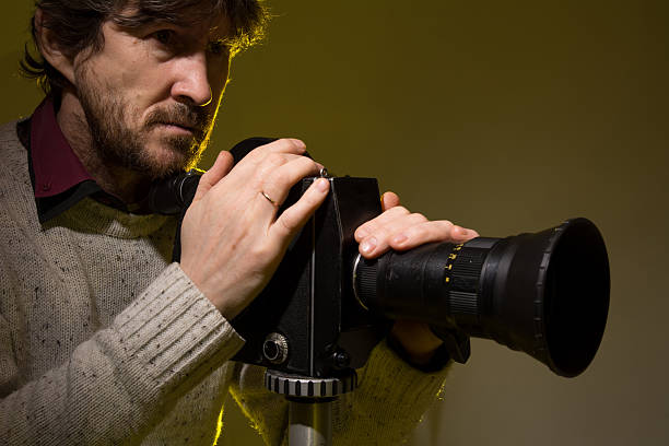 istock Man with old film movie camera. 512967586