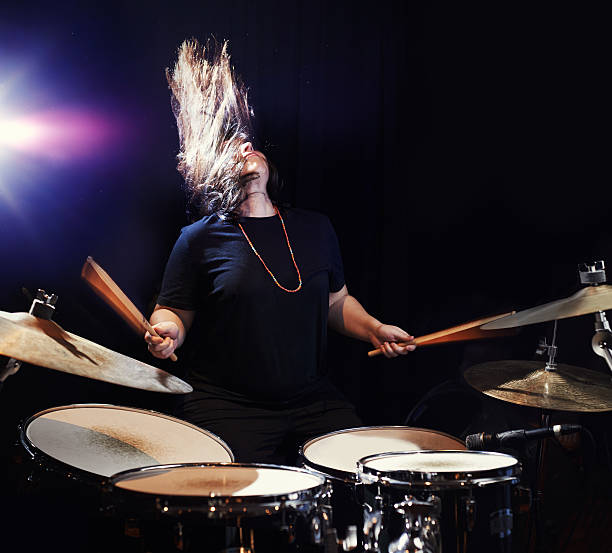 Music to bang her head to! Shot of a young woman rocking out on drumshttp://195.154.178.81/DATA/i_collage/pu/shoots/806435.jpg drummer stock pictures, royalty-free photos & images