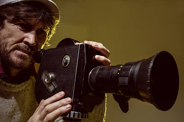 istock Man with old film movie camera 512967884