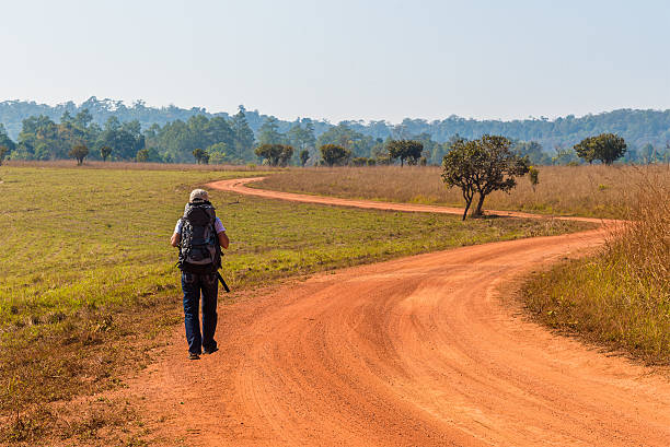 istock Woman Traveler with Backpack on dirt road. 512969010