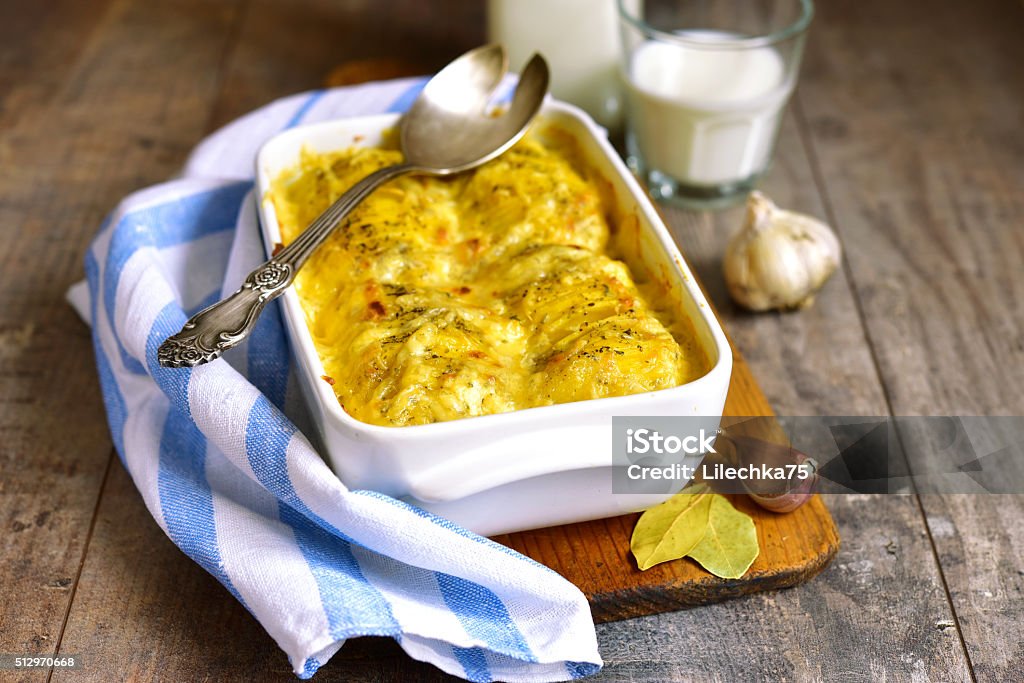 Potato gratine. Potato gratine in a baking form on rustic background. Prepared Potato Stock Photo