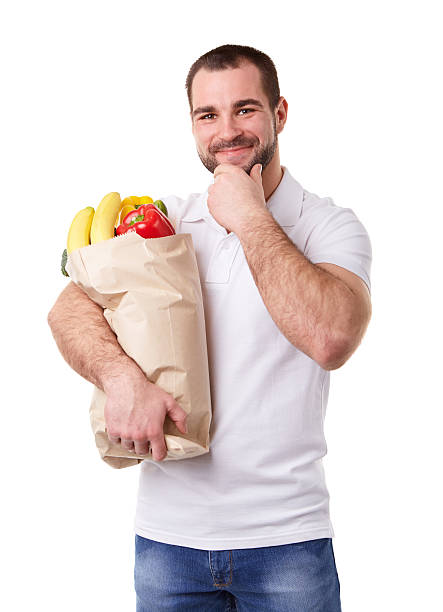 istock Pensive man holding paper bag full of vegetables 512971086