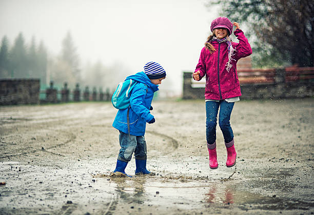 istock Brother and sister hikers playing in a puddle 512972236