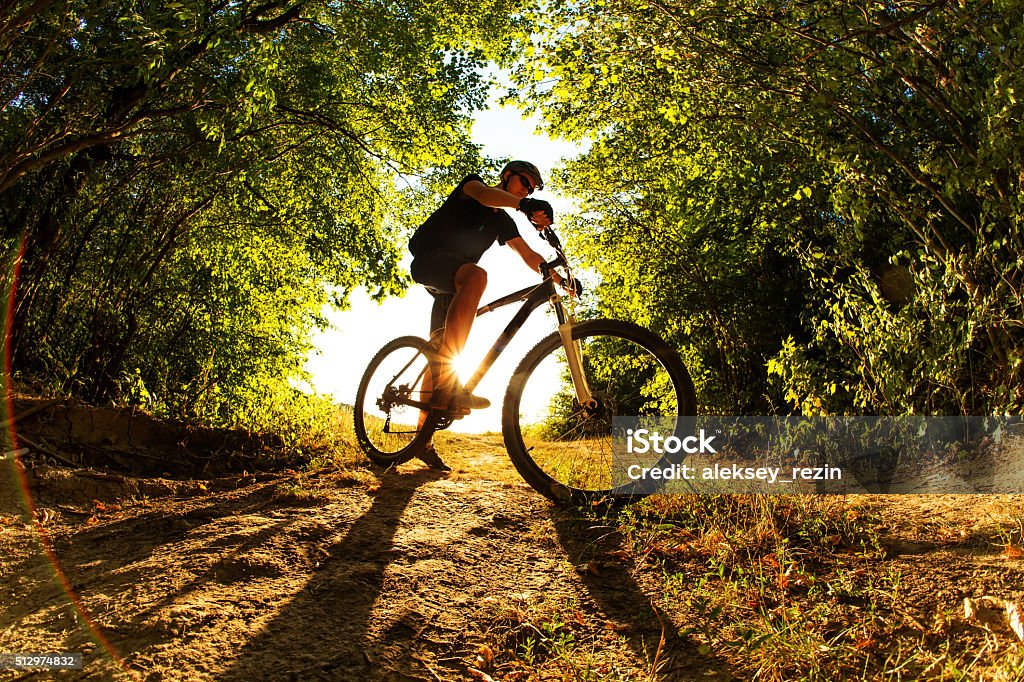 Man Cyclist with bike on sunset Silhouette of a biker on sky background on sunset with focus on bike Mountain Bike Stock Photo