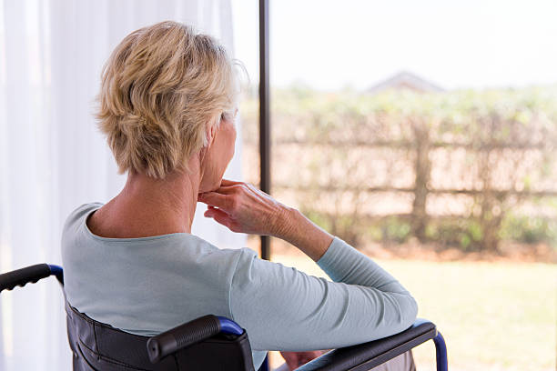 istock handicapped senior woman looking through window 512977352