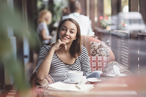 istock Young woman drinking coffee in urban cafe 512977879