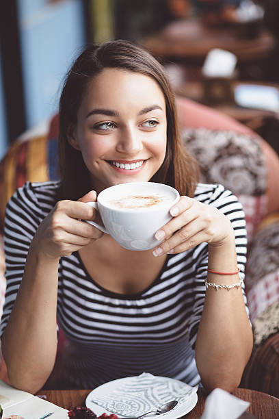 istock Young woman drinking coffee in urban cafe 512978125
