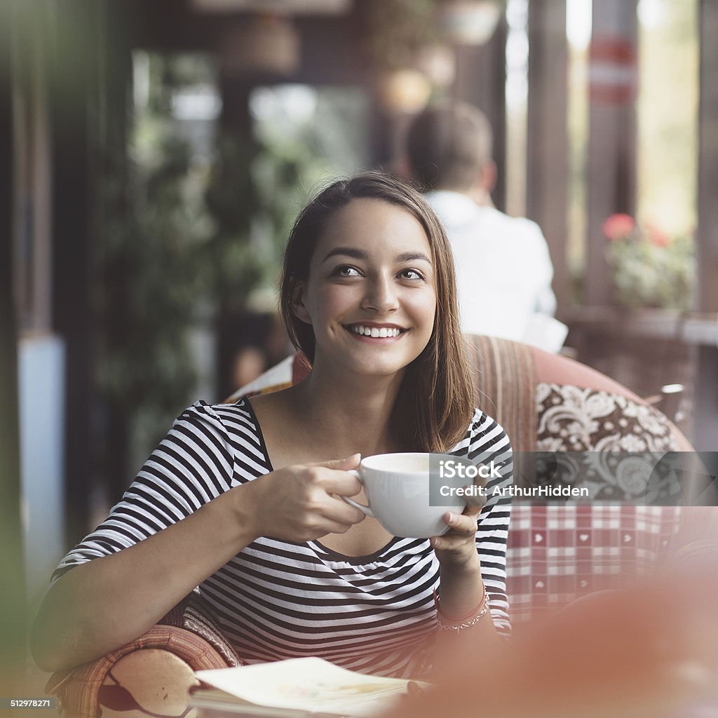 Young woman drinking coffee in urban cafe Adult Stock Photo