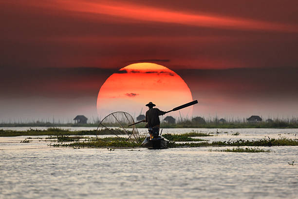 örtliche fischer im sonnenuntergang hintergrund - myanmar stock-fotos und bilder