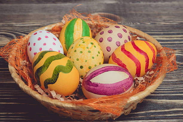 istock Easter eggs in basket on wooden boards 512979034
