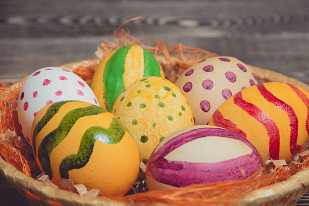 istock Easter eggs in basket on wooden boards 512979414