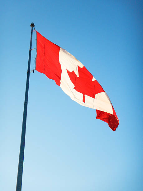 istock canadian flag waving on the sky 512979667