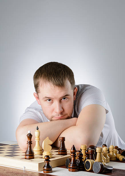 istock Man lying on the folded hands of chess board 512981176