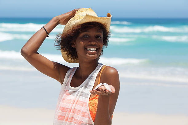 istock Smiling young woman with seashell at the beach 512981240