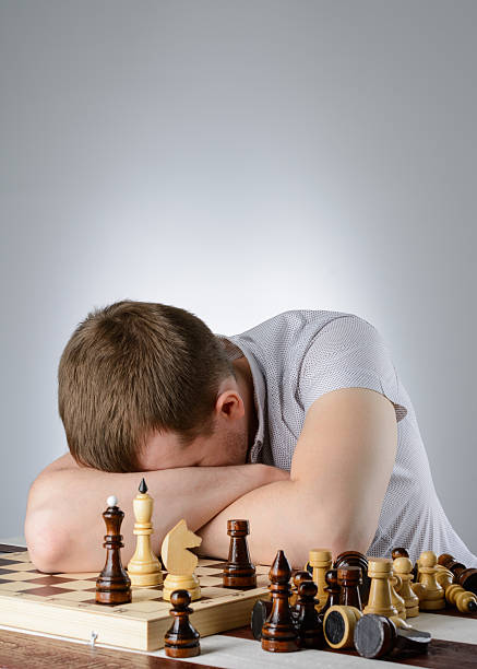 istock Man lying on the folded hands of  chess board 512981270