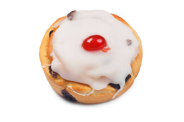 Iced Bun Angled view of an iced bun isolated on white iced bun stock pictures, royalty-free photos & images