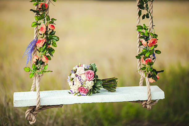 istock Wedding bouquet of peonies lying on white bench swing decorated 512984292