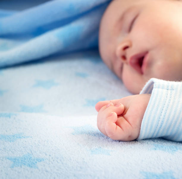 istock three month old baby sleeping on blue blanket 512986594