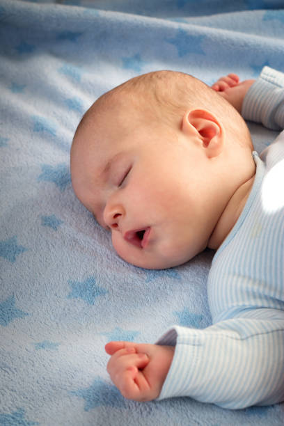 istock three month old baby sleeping on blue blanket 512986652