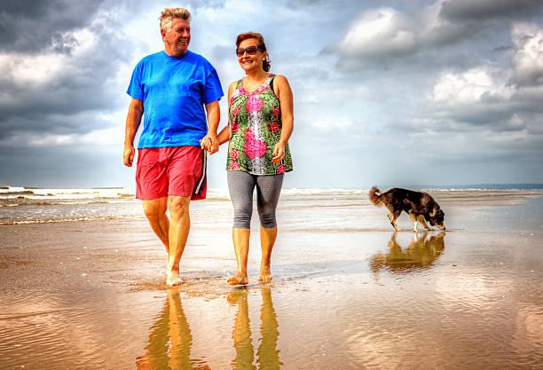 istock Mature laughing couple walking on the seashore 512987237