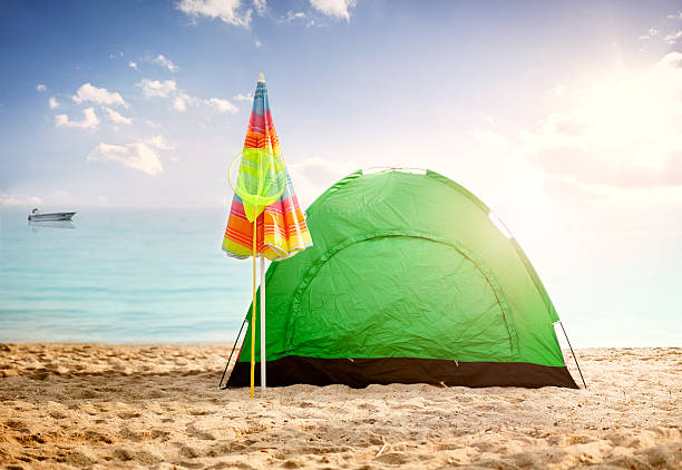 tent on beach at sunset,clouds sea and little ship in background