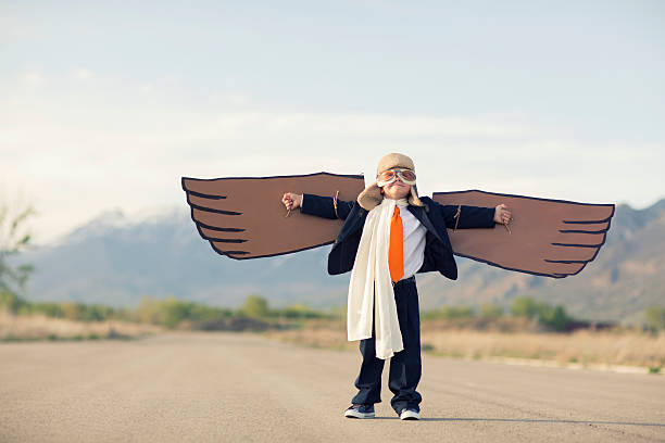 junge geschäftsmann, gekleidet in anzug mit karton flügel - taking off business creativity adventure stock-fotos und bilder