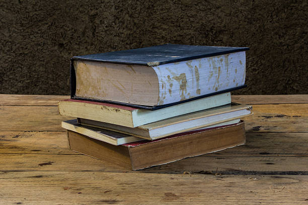 istock Vintage old books on wooden deck table with soil wall 512989815