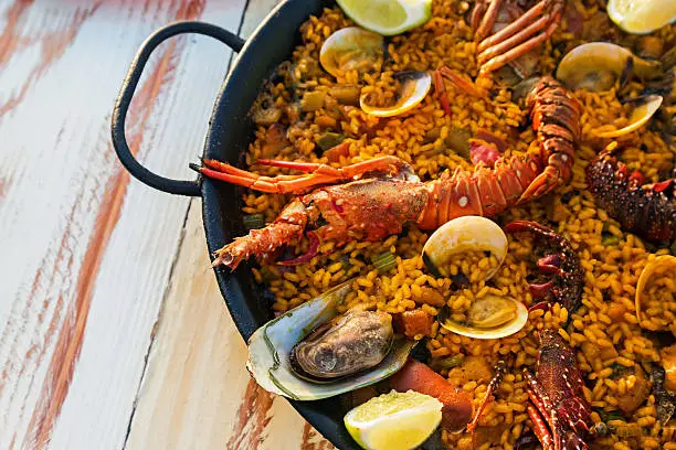 Seafood paella on the wooden table close-up