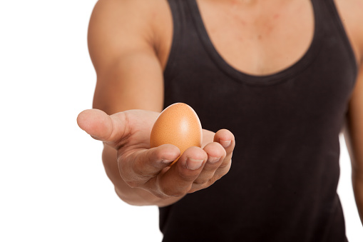 Egg in muscular Asian man's arm  isolated on white background