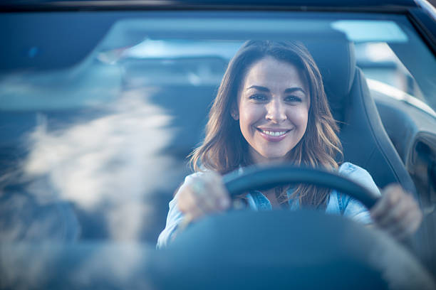 Woman driving a car Happy woman driving a car and smiling showroom photos stock pictures, royalty-free photos & images