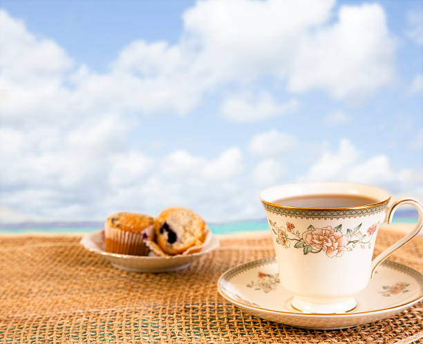 istock Tea, muffins on beach, sky background.  Breakfast. Relaxation. 512995336
