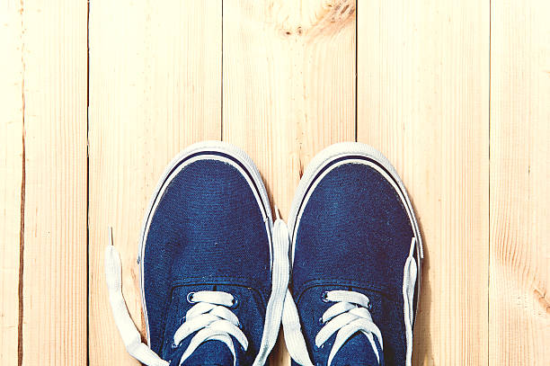 istock Blue sneakers on wooden background with copy space. Top view 512995884