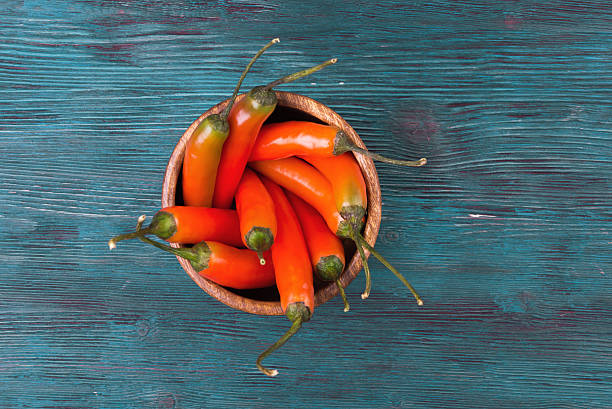 istock Top view of chili in wooden plate over rustic background 512995948