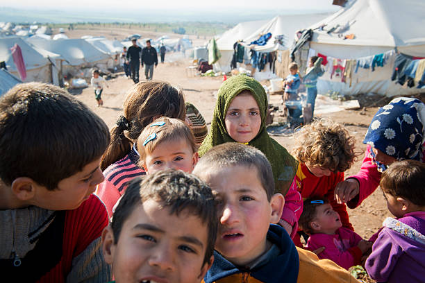 Syrian refugees inside Syria Atmeh, Syria - January 14, 2013: Internally displaced Syrians, including children, at a refugee camp near the Turkish border in Atmeh, Syria middle eastern clothes stock pictures, royalty-free photos & images