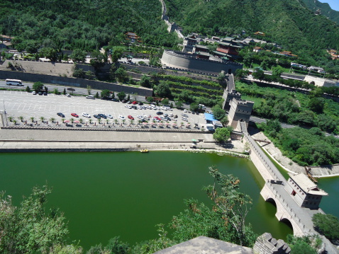 A green lagoon, cars and the great wall by juyong china taken from up on the hill.