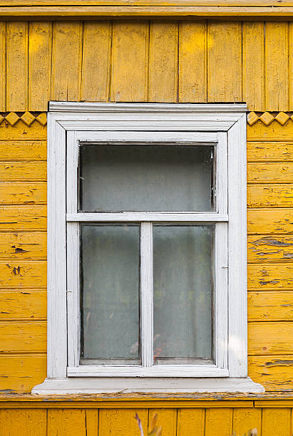 istock Russian rural house fragment, yellow wall and white window 513024185
