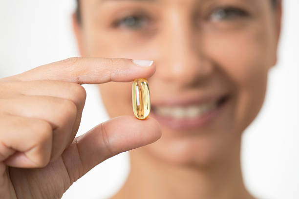 woman holding とソフトなジェルを発表 - fish oil pill healthy lifestyle protection ストックフォトと画像