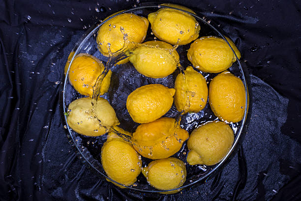 yellow lemonyellow lemon splashing in water on black background