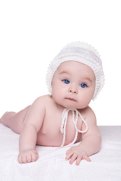 istock baby child lying down on blanket wearing white hat, isolated 513040794