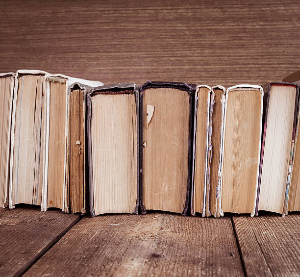 istock Old books on wooden background 513041506