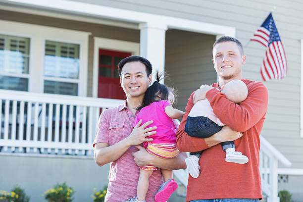 istock Two fathers holding young children standing outdoors 513045492