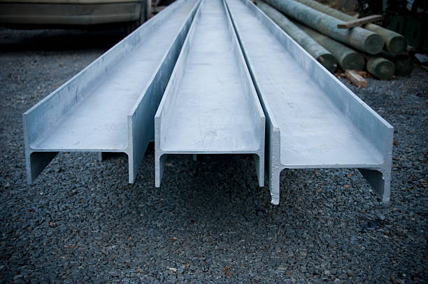 Three structural steel I-beams awaiting construction