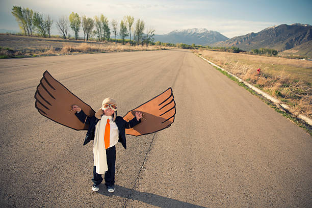 istock Young Boy Businessman Dressed in Suit with Cardboard Wings 513047180