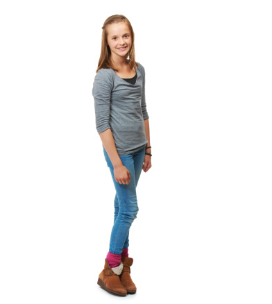 Full-length studio portrait of a happy teenage girl standing against a white background