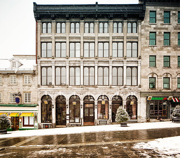 Four stories building in Old Montreal during snow storm. This building is built on a slope.