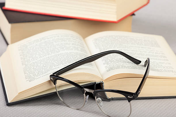 istock Close up of reading glasses laying on a book 513053664