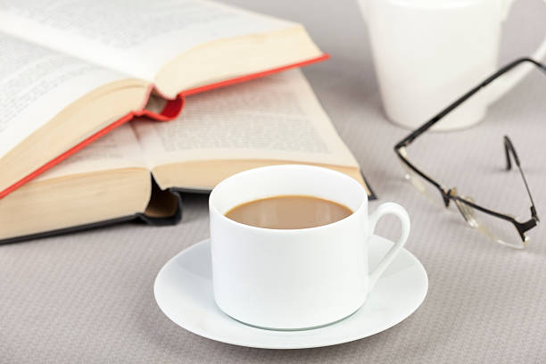 istock Cup of coffee on the table with two books 513053714