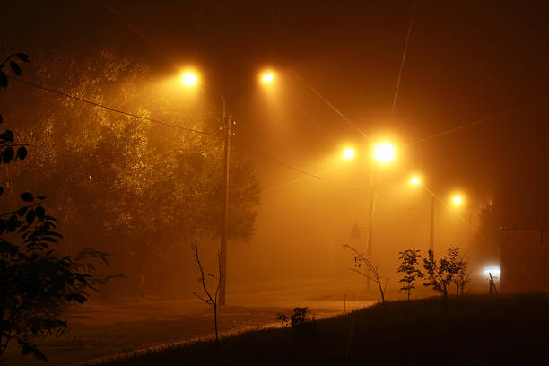 istock Foggy street in yellow light at night 513053808