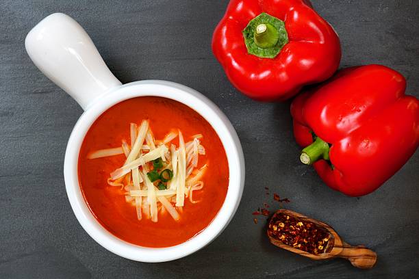 istock Red pepper soup overhead scene on slate background 513054200